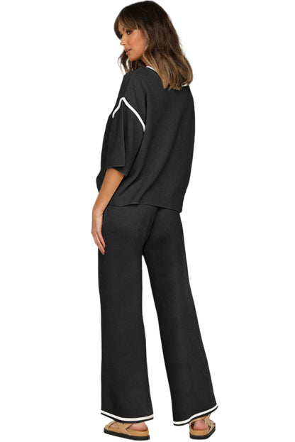 Woman wearing a black outfit with white accents on a plain background