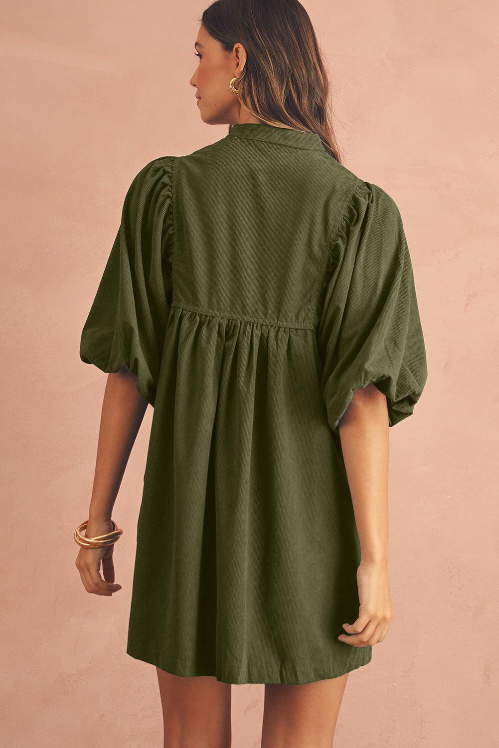 Back side of an olive green babydoll mini dress with puff sleeves , perfect dress for spring occasion.