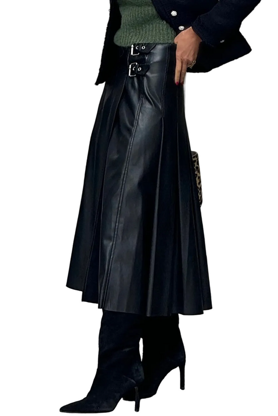 Person wearing a black leather skirt and high-heeled boots on a city street.