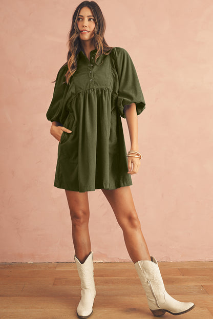 Model in an olive green babydoll mini dress with puff sleeves and white boots, ideal for spring occasions