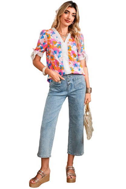 Woman wearing a colorful floral blouse and blue jeans on a white background