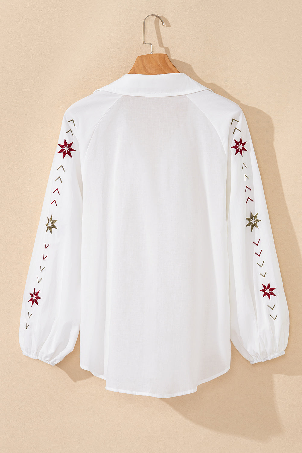 The back view of the white embroidered shirt highlights its puff long sleeves, making it a perfect choice for the summer season.