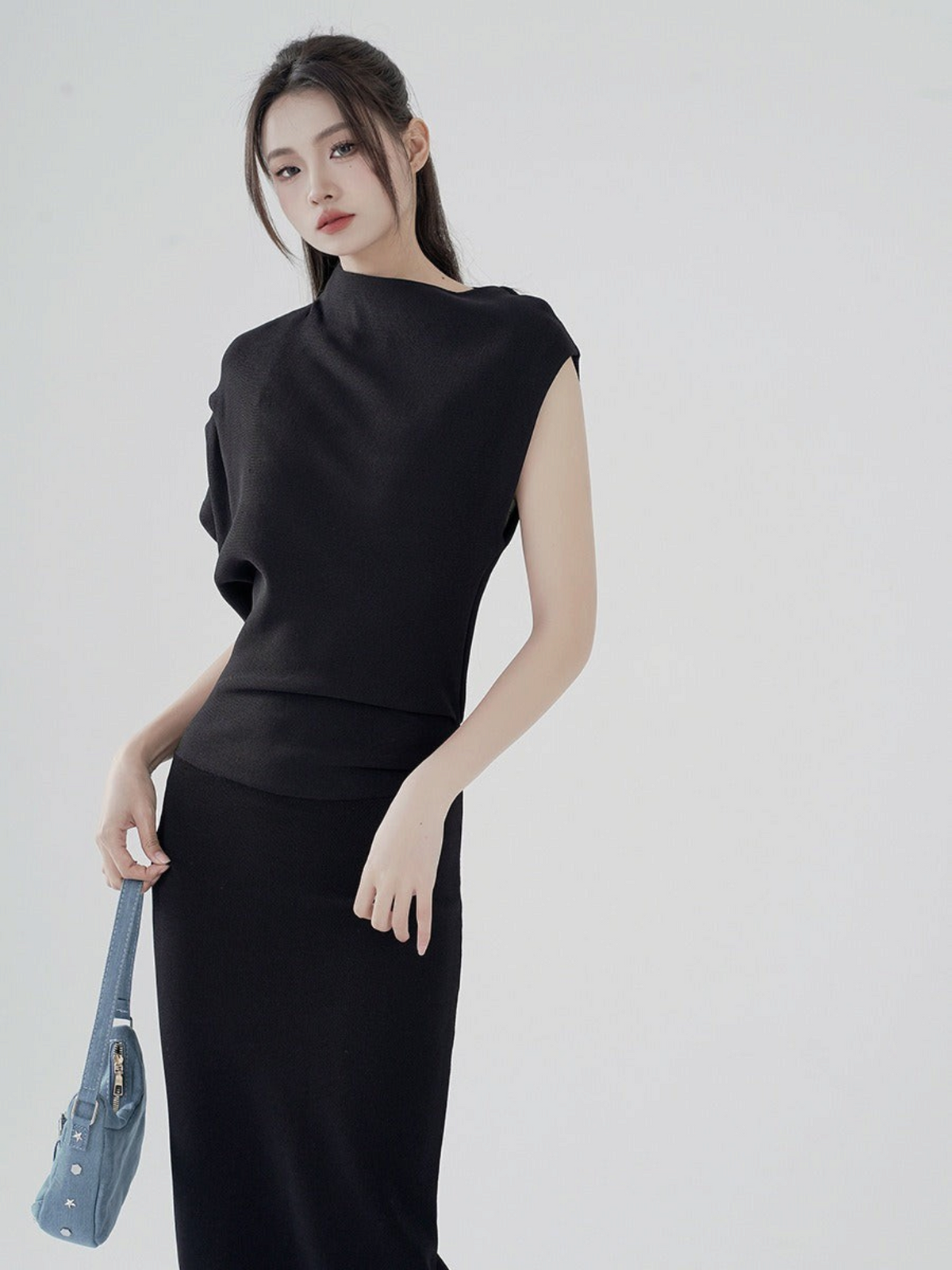Catherine Martin black two-piece set with asymmetric funnel neck top and fitted midi skirt on a model