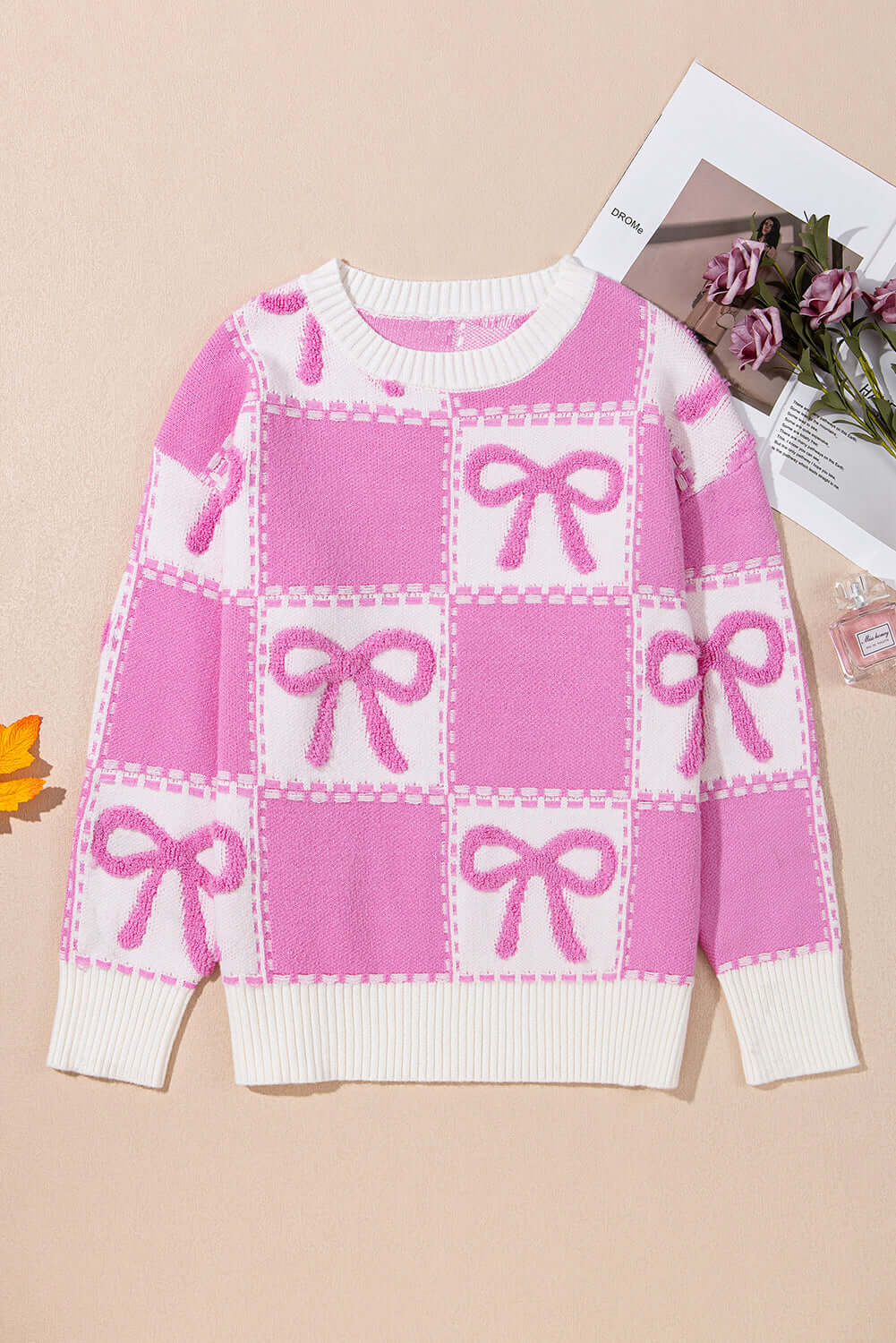 Pink bow knit sweater with a relaxed fit, perfect for layering.
