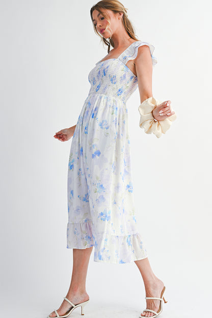 Woman wearing a white floral dress with blue flowers on a plain background