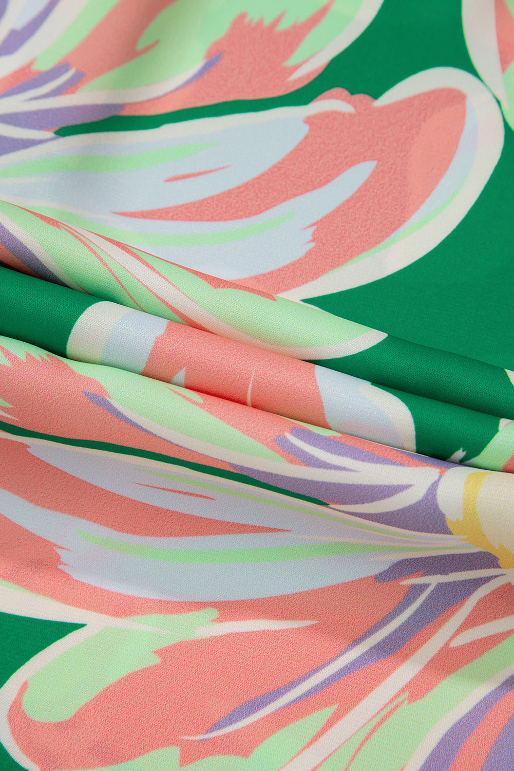 A close-up view of the fabric on the green floral blouse with long sleeves.