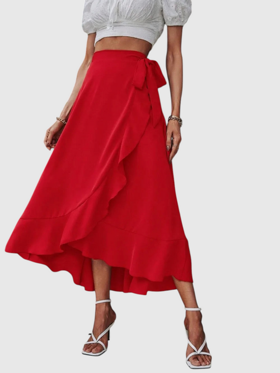 Catherine Martin red midi wrap skirt with ruffle trim, side tie, and asymmetric high-low hem on a model