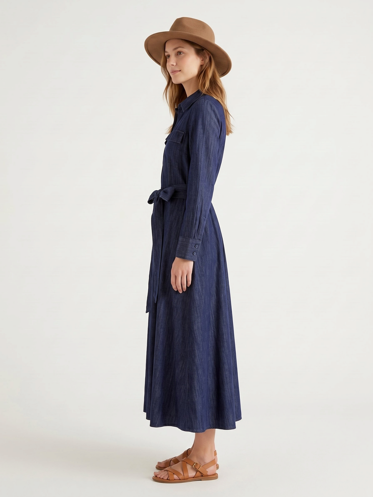Catherine Martin dark indigo denim maxi shirt dress with a self-tie waist, worn by a model with a brown fedora hat.
