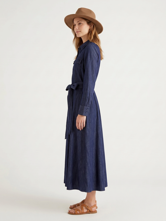 Catherine Martin dark indigo denim maxi shirt dress with a self-tie waist, worn by a model with a brown fedora hat.