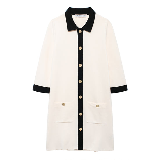 A flat lay product image of the white knit mini polo dress, featuring a structured black contrast shirt collar, black front placket, and embossed gold-tone buttons.