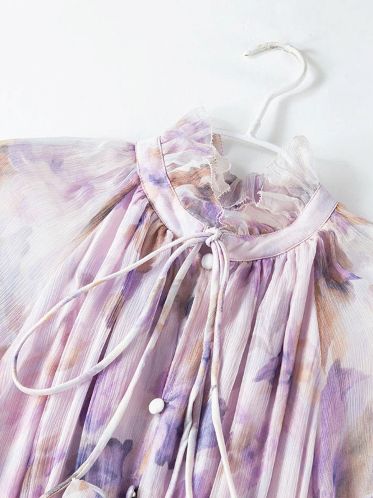 Catherine Martin lilac floral chiffon dress featuring a ruffled stand collar, tie neck, and delicate petal trims.
