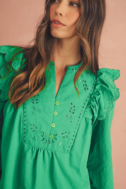 The closed-up view of green embroidered mini dress. It features with frill shoulders and 3/4 sleeves.