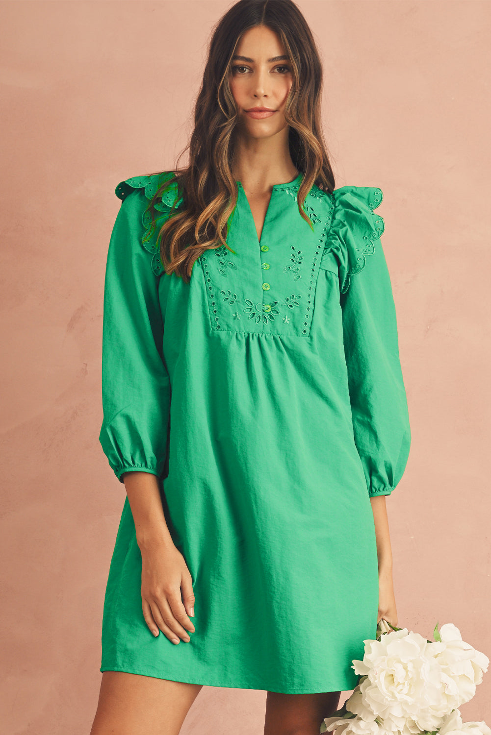 3/4 shot view of a green embroidered mini dress featuring frill shoulders and 3/4 sleeves.