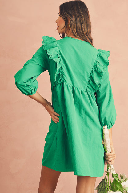 The back view of green embroidered mini dress. It features with frill shoulders and 3/4 sleeves.