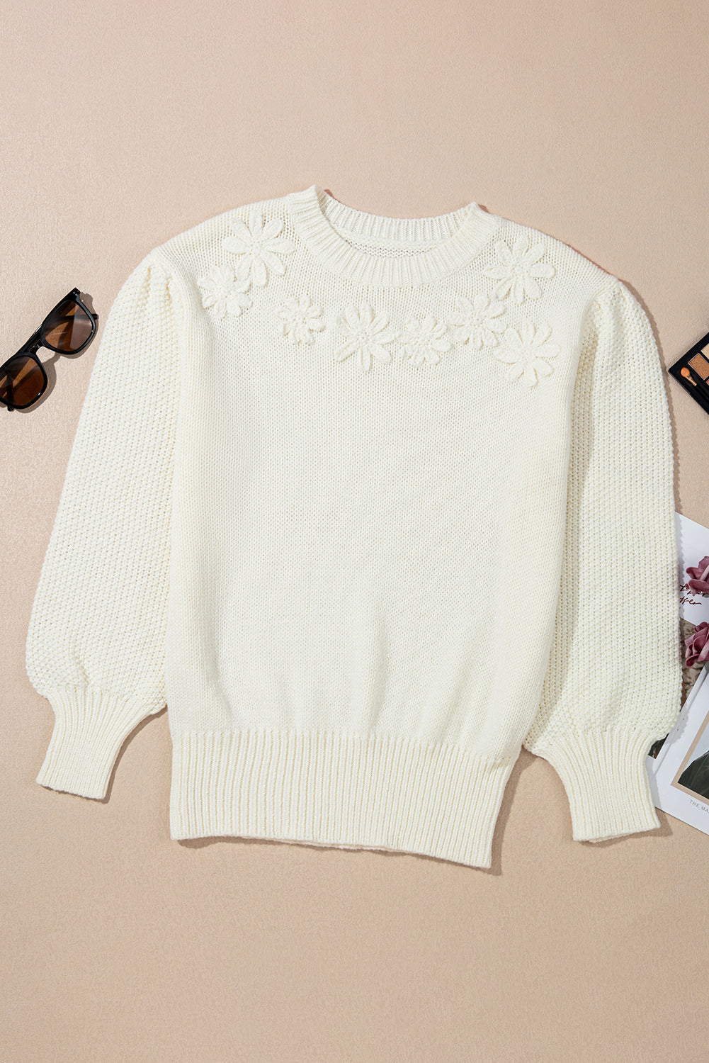 White sweater with floral pattern on a beige background