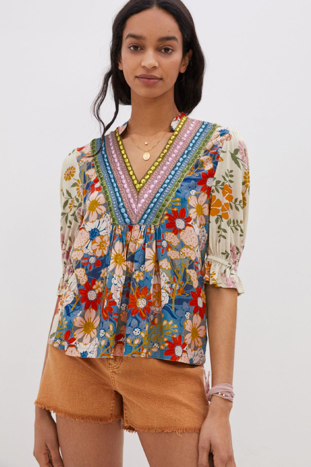 A model standing in a multicolor boho blouse with a V-neck and half sleeves.