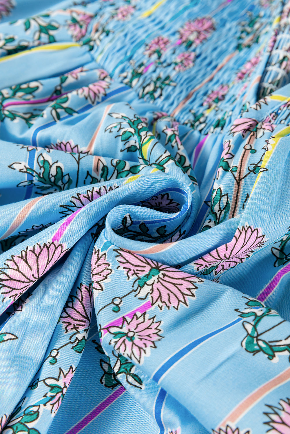 Close-up view of the fabric on a light blue striped floral blouse with half sleeves.