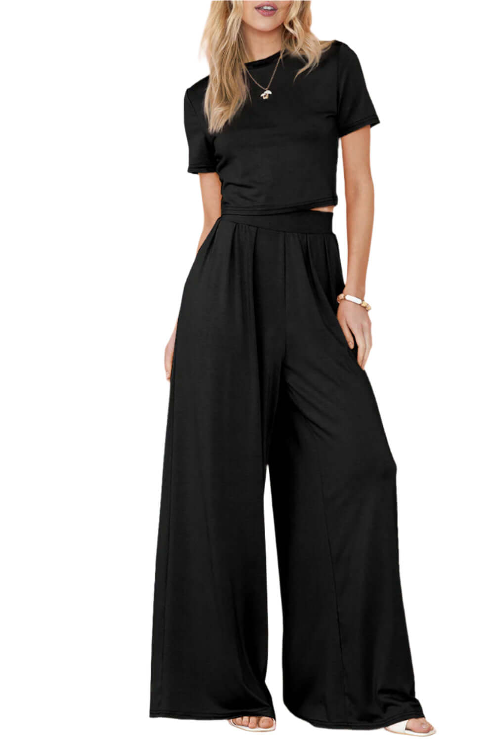 Woman wearing black two-piece set with a cropped tee and wide-leg pants.

