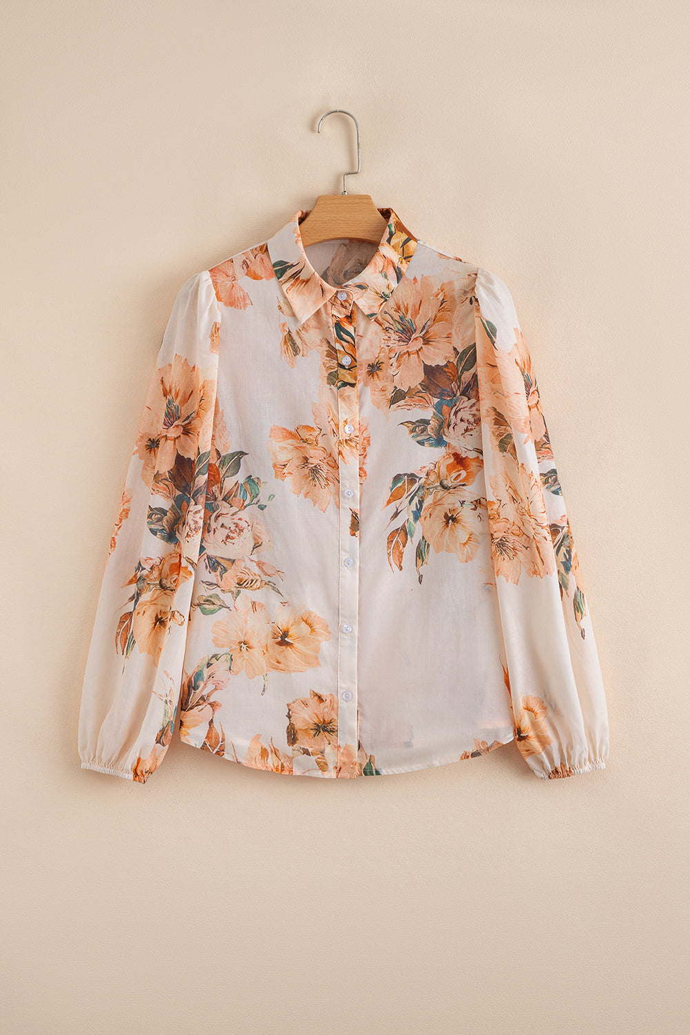 Floral blouse on a hanger against a beige background