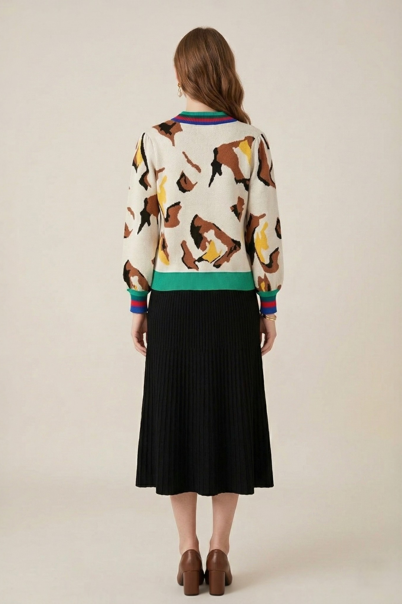 Abstract print stripe trim knit sweater back full length view styled with black pleated midi skirt and brown heels