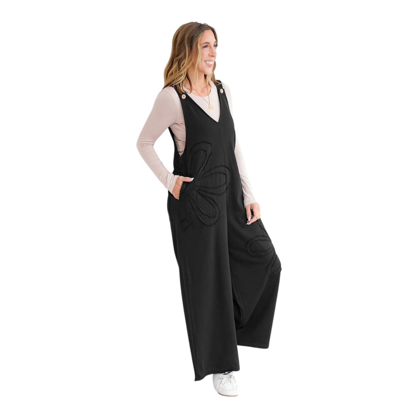 Woman wearing a black jumpsuit with a white background