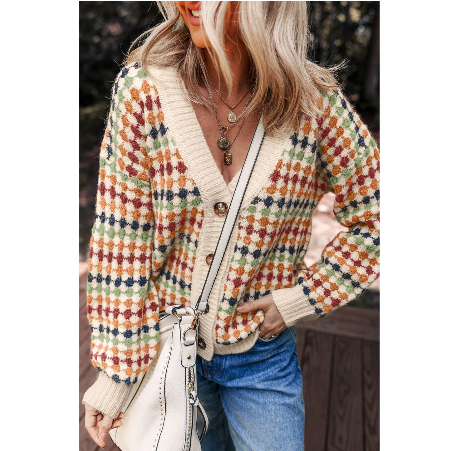 Person wearing a colorful patterned cardigan with a blurred background