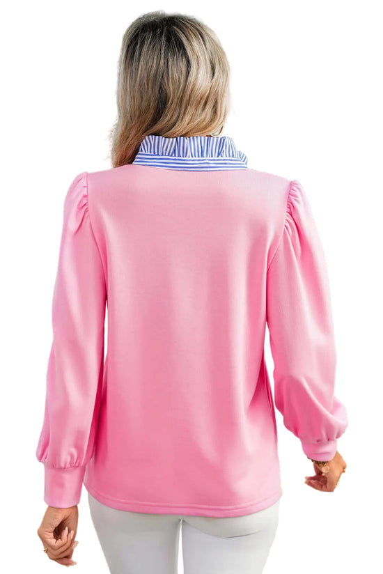 Woman wearing a pink long-sleeve top with a blurred background