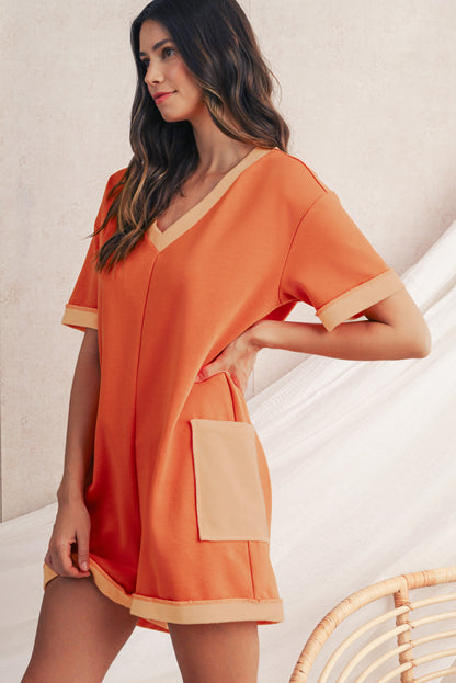 Woman wearing an orange dress with a pocket on a neutral background