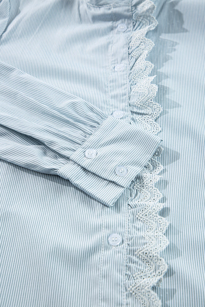 Close-up view of the fabric on a blue striped long sleeve shirt with lace trim.