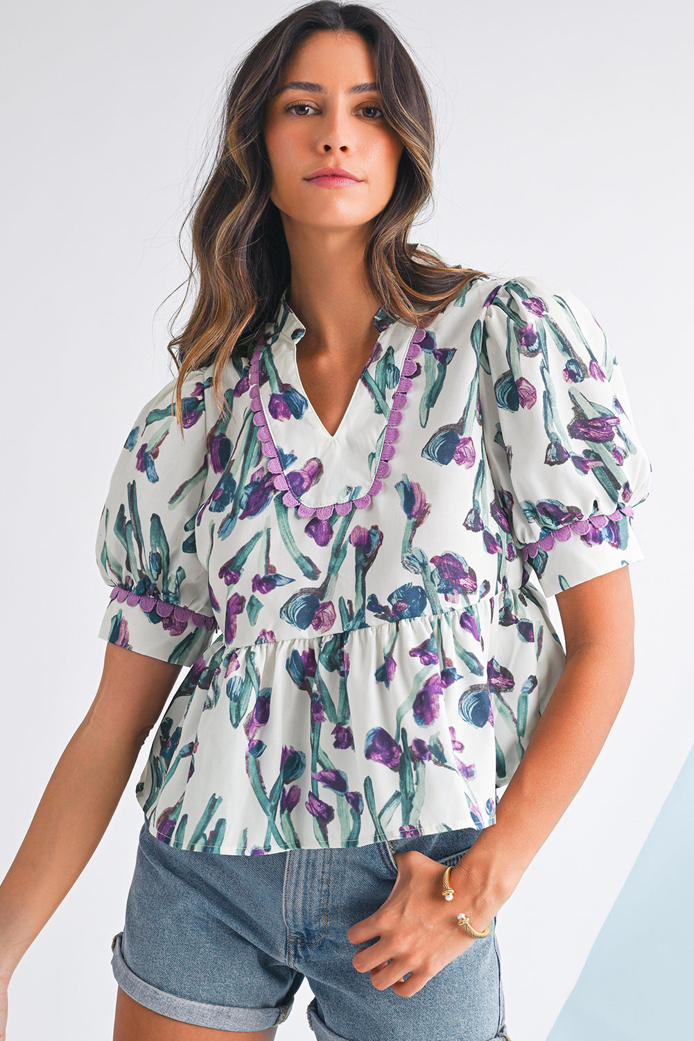 Woman wearing a floral blouse with puffed sleeves on a white background