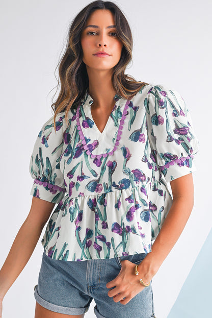 Woman wearing a floral blouse with puffed sleeves on a white background
