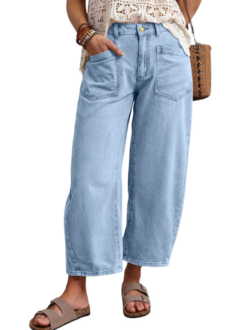 A person wearing light-wash wide-leg cropped denim pants, paired with a cream crochet top, brown sandals, and a brown crossbody bag, shown against a plain white background.