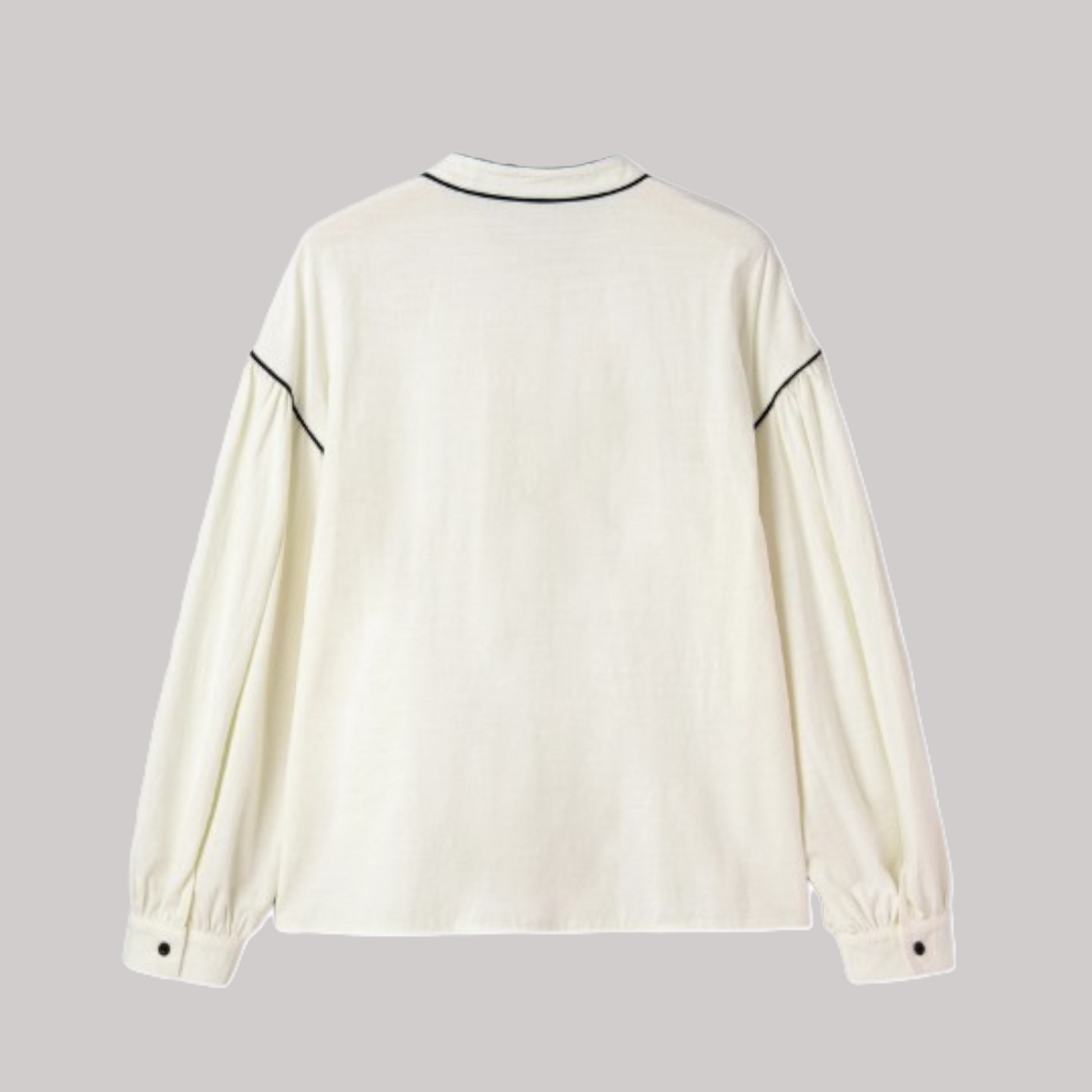 Rear view of a relaxed-fit cream blouse showcasing voluminous bishop sleeves and horizontal black contrast trim across the shoulders.
