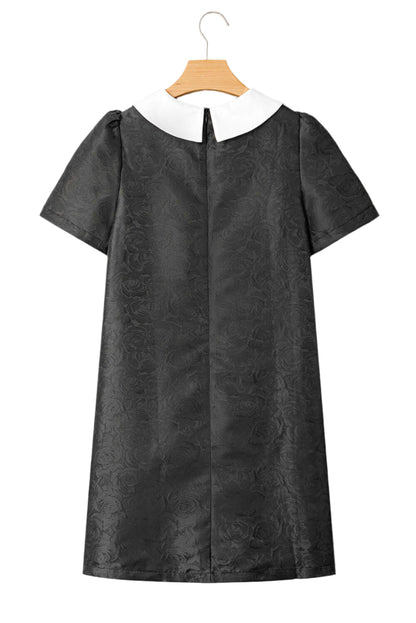 Back view of the black mini dress with puff sleeves and a concealed zipper.