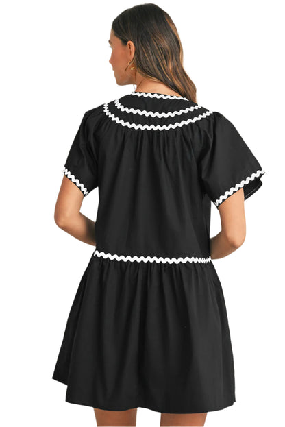 Black view of a black mini dress with ric rac details.