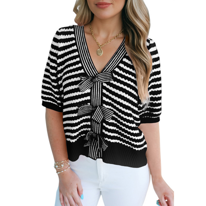 Front view of a black and white striped textured knit sweater showing the seamless pattern and ribbed hemline.