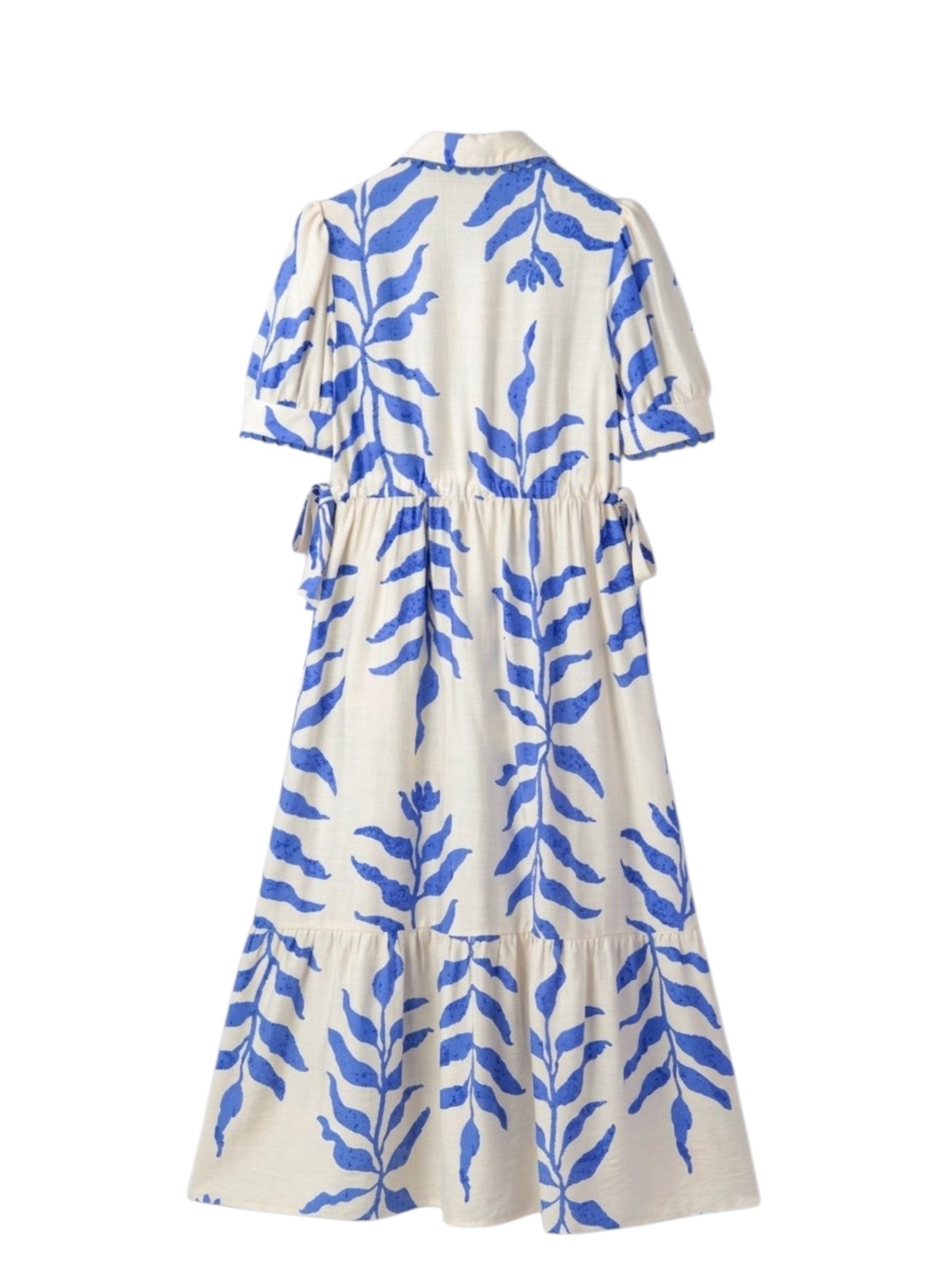 A cream-colored midi dress with a blue botanical leaf print, featuring short puff sleeves, a tie waist, and a tiered skirt, shown from the back against a white background.