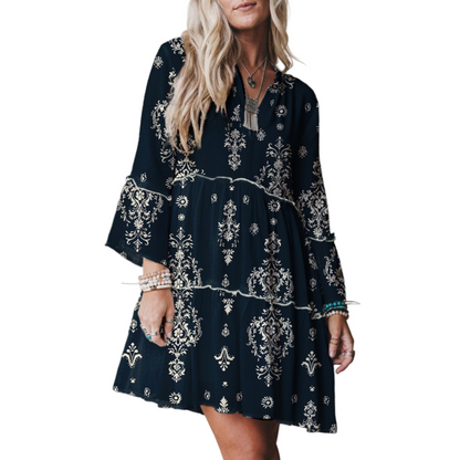 Navy blue dress with white patterns worn by a person on a plain background