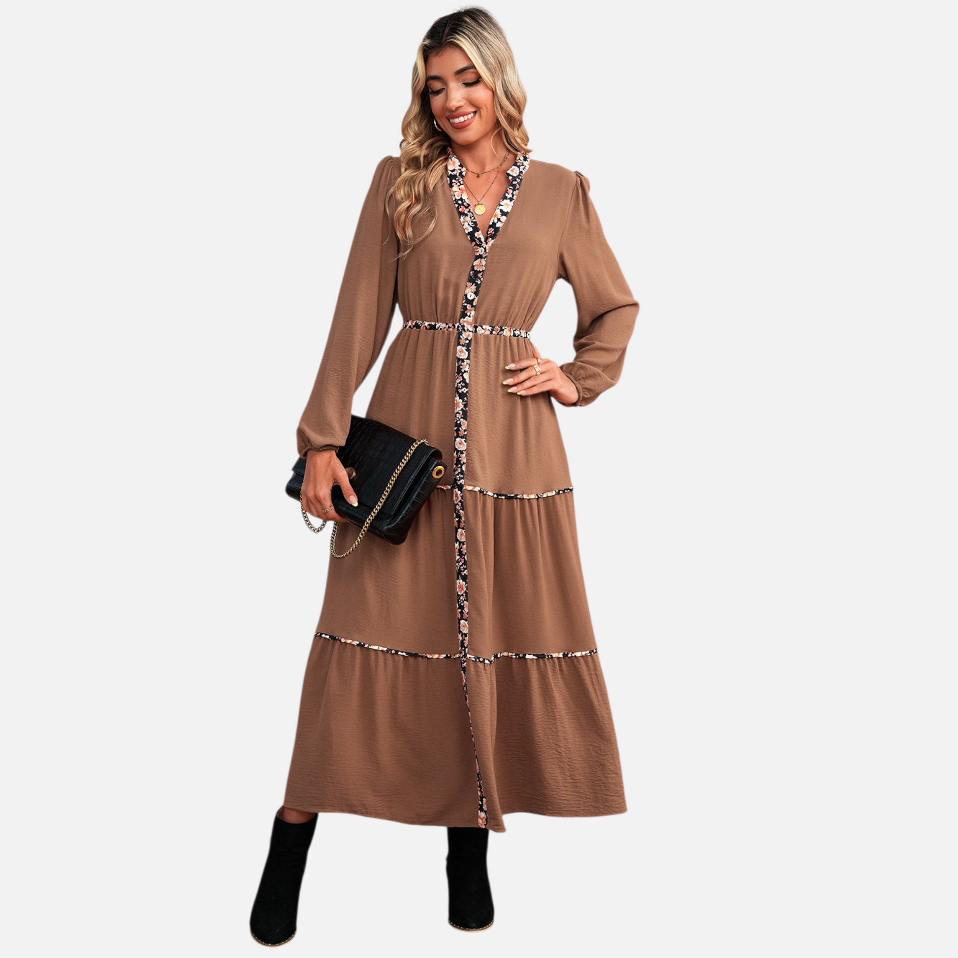 A model showcasing a brown tiered maxi dress featuring a notched neckline and elegant floral trim detail, styled for a casual yet sophisticated look.