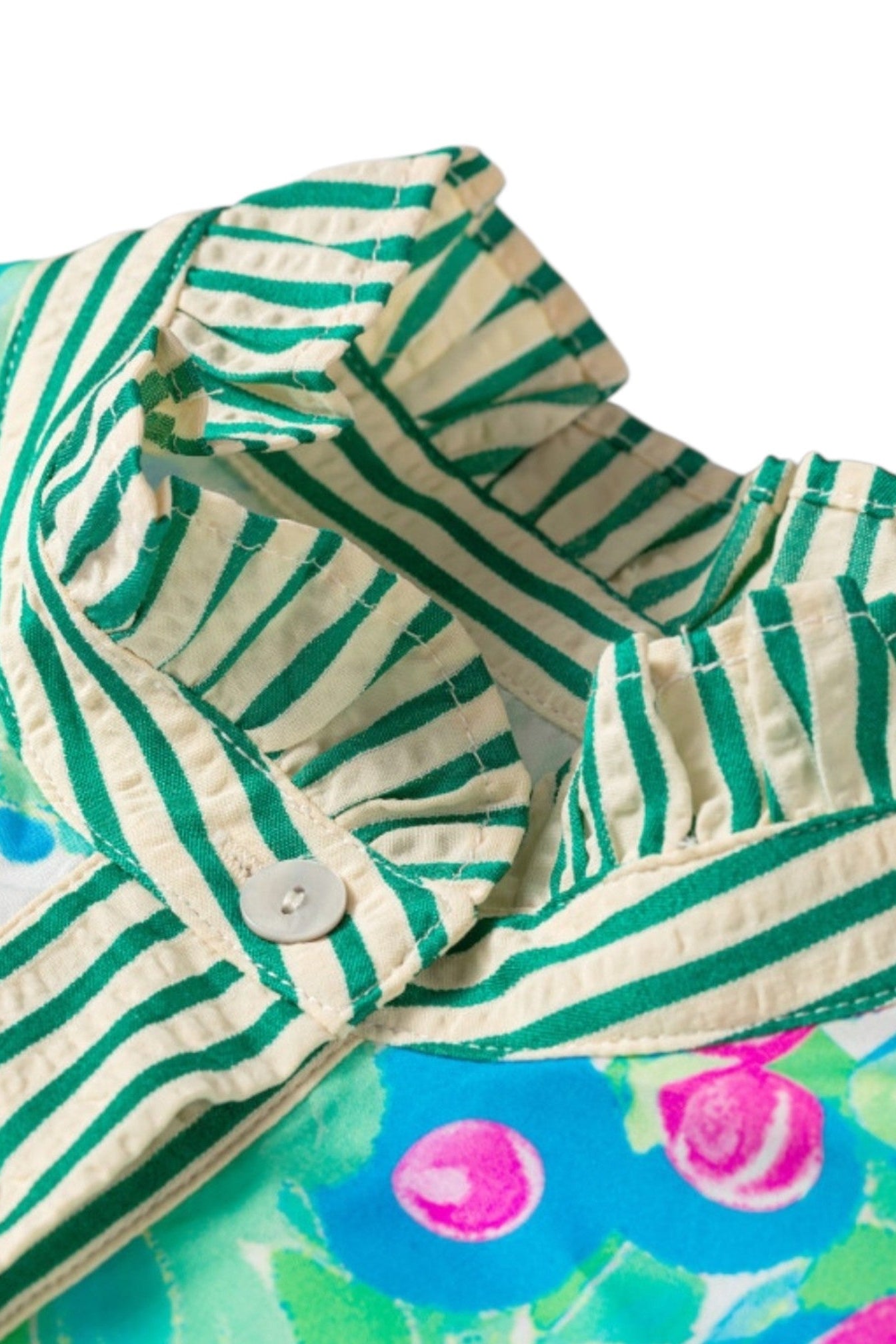Close-up of a ruffled collar on a children's shirt, featuring green and cream stripes on the front panel and a colorful floral print on the back.