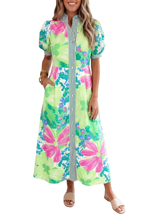 A woman modeling a short-sleeve maxi dress with a vibrant floral print in lime green, pink, and blue, featuring a striped collar and front placket.