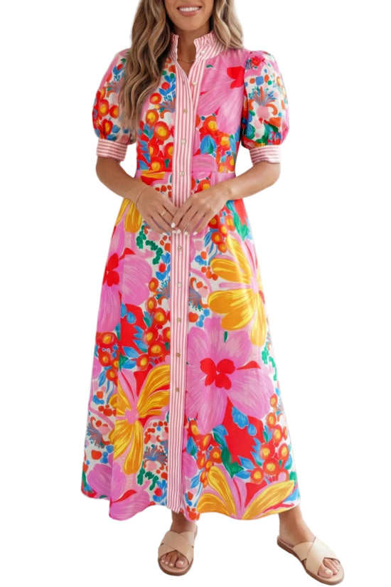 Woman wearing a colorful floral dress standing against a white the background