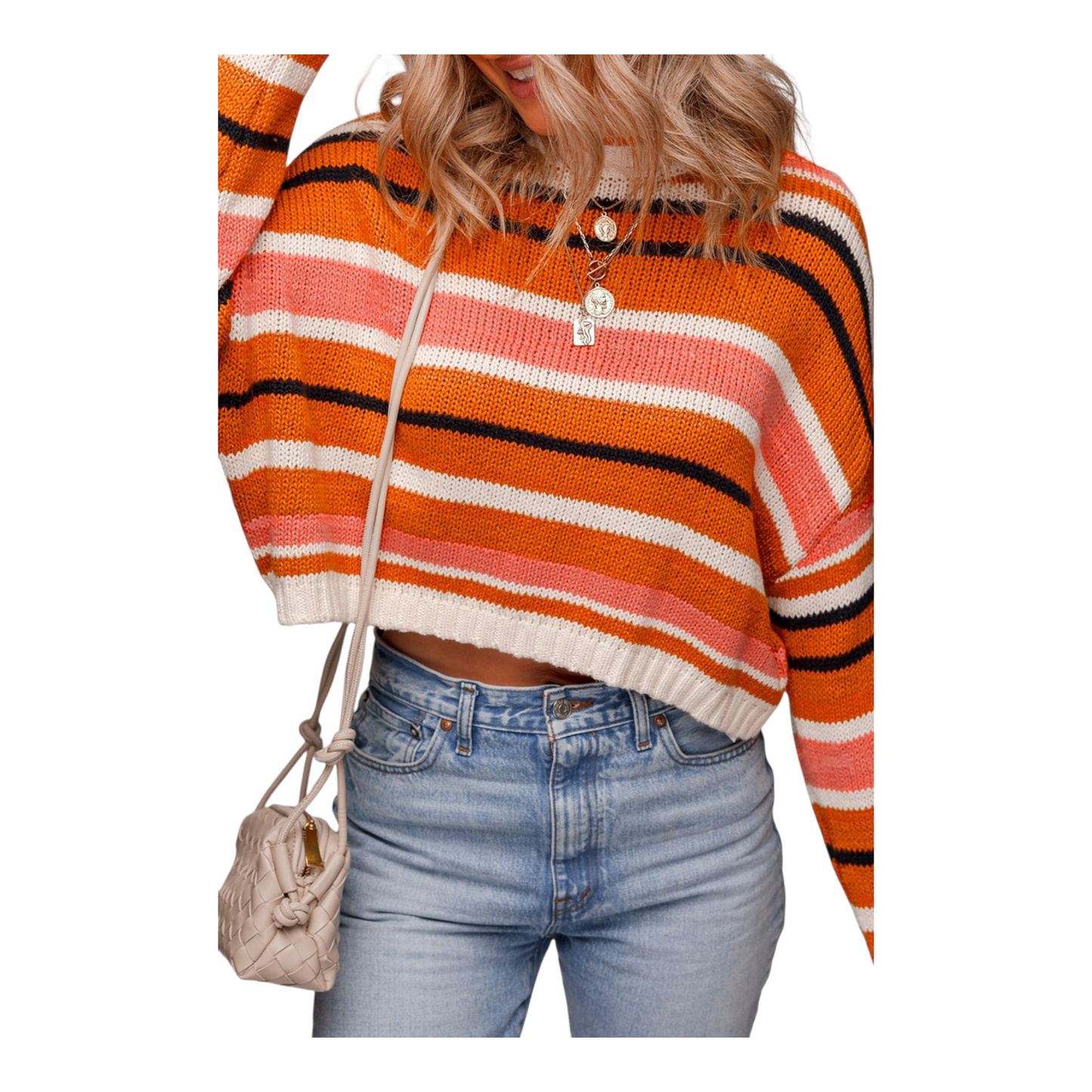 Person wearing a colorful striped sweater and jeans with a beige bag on a white background