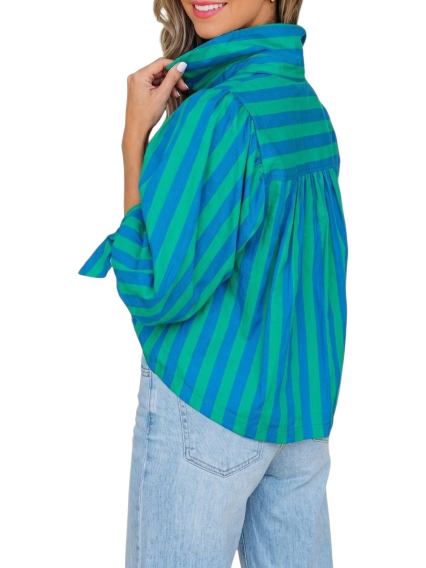 Green and blue striped sweater worn by a person on a white background