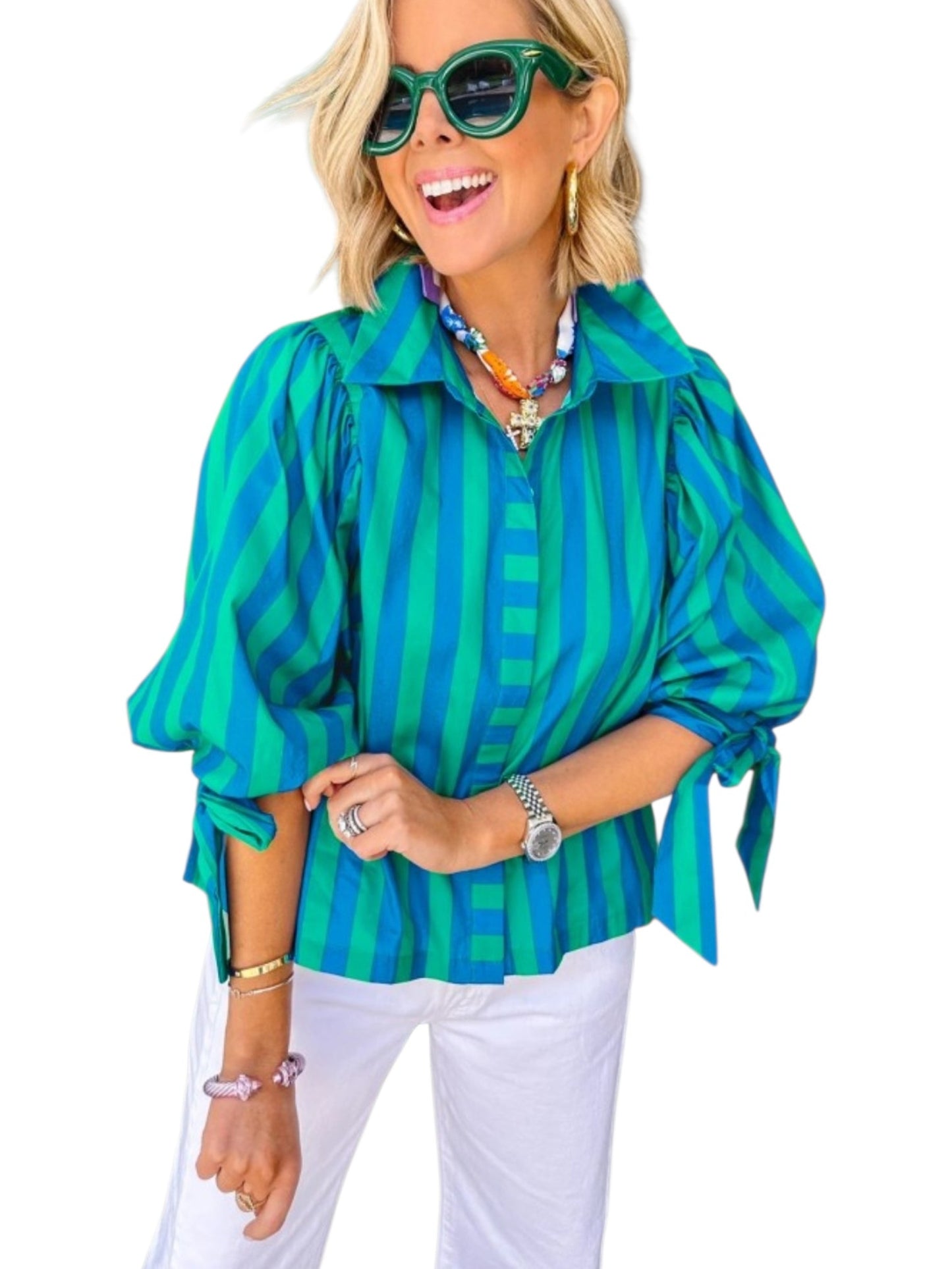 Woman wearing a green and blue striped shirt with white pants on a white background