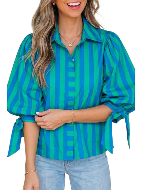 Woman wearing a blue and green striped shirt with rolled-up sleeves on a white background