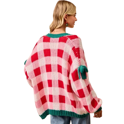 Person wearing a red and white checkered sweater with green trim on a white background