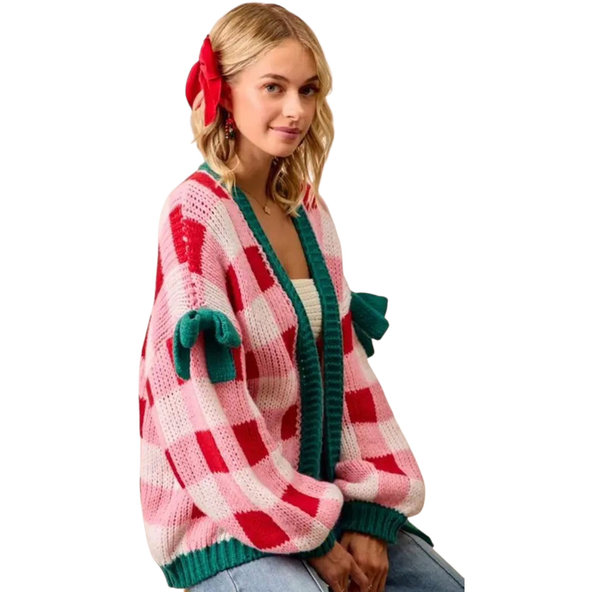 Woman wearing a colorful cardigan with red and green accents on a white background