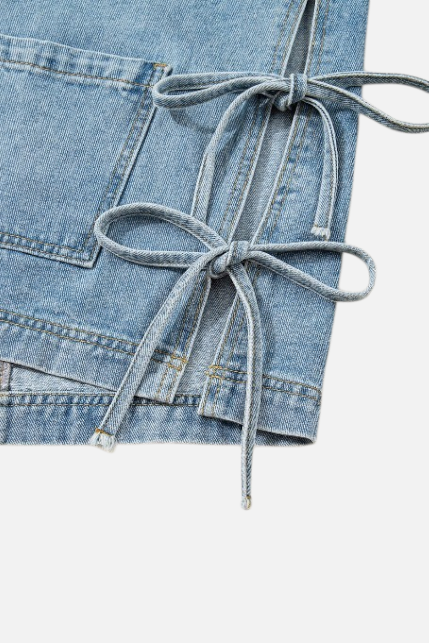 Light blue denim skirt with tied waistband on a white background