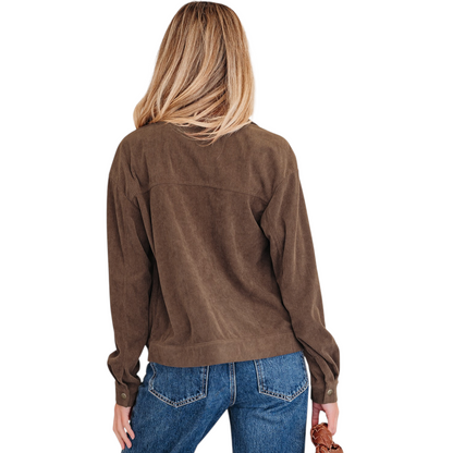 The rear view of a woman wearing a tailored brown corduroy jacket, showcasing the horizontal back yoke and clean-lined ribbed texture.